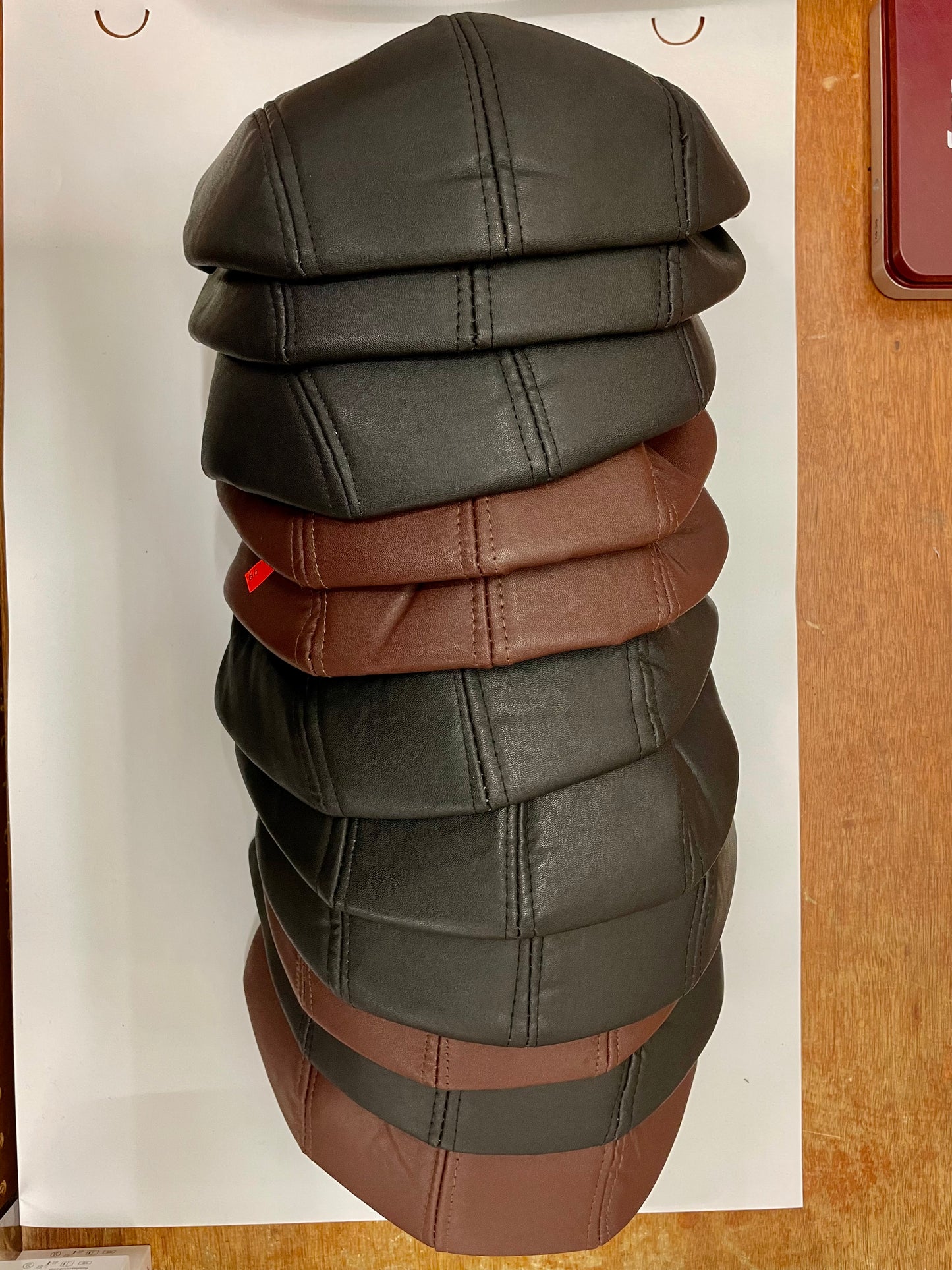 "Navy blue leather flat hat with a quilted texture and a drawstring closure"