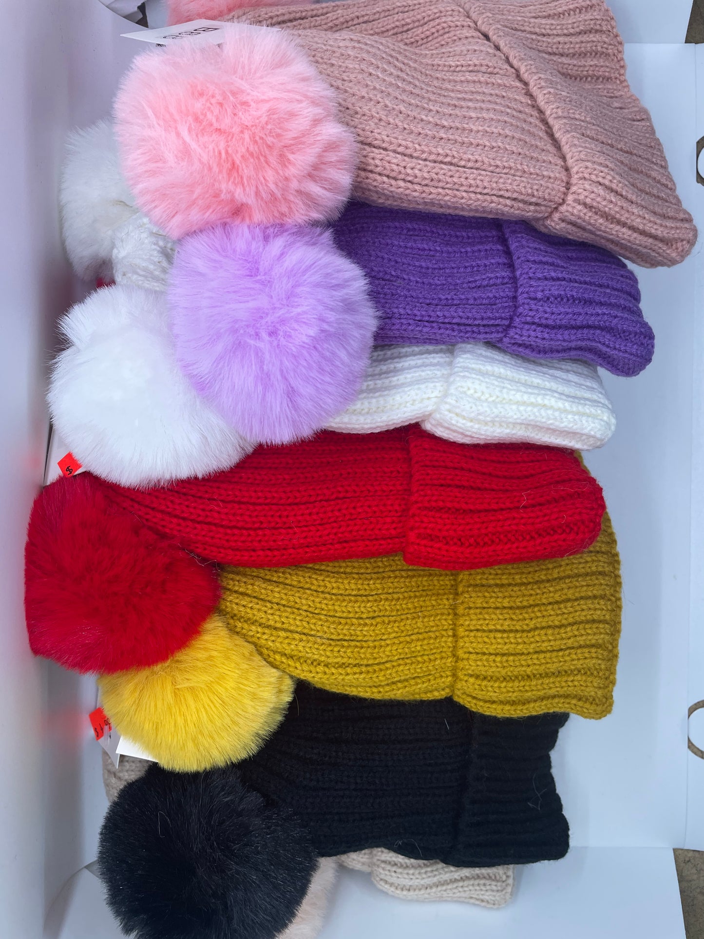 "Pink kid's toboggan hat with a knit flower detail and a fold-over cuff"