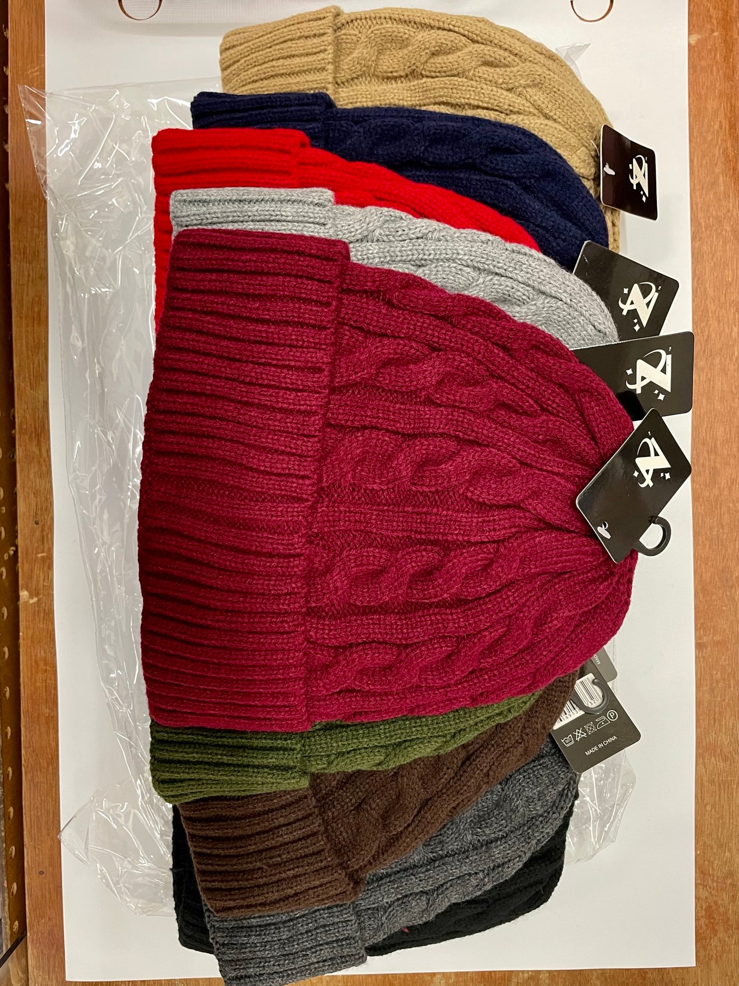 "Black knitted beanie with a knit flower detail and a fold-over cuff"