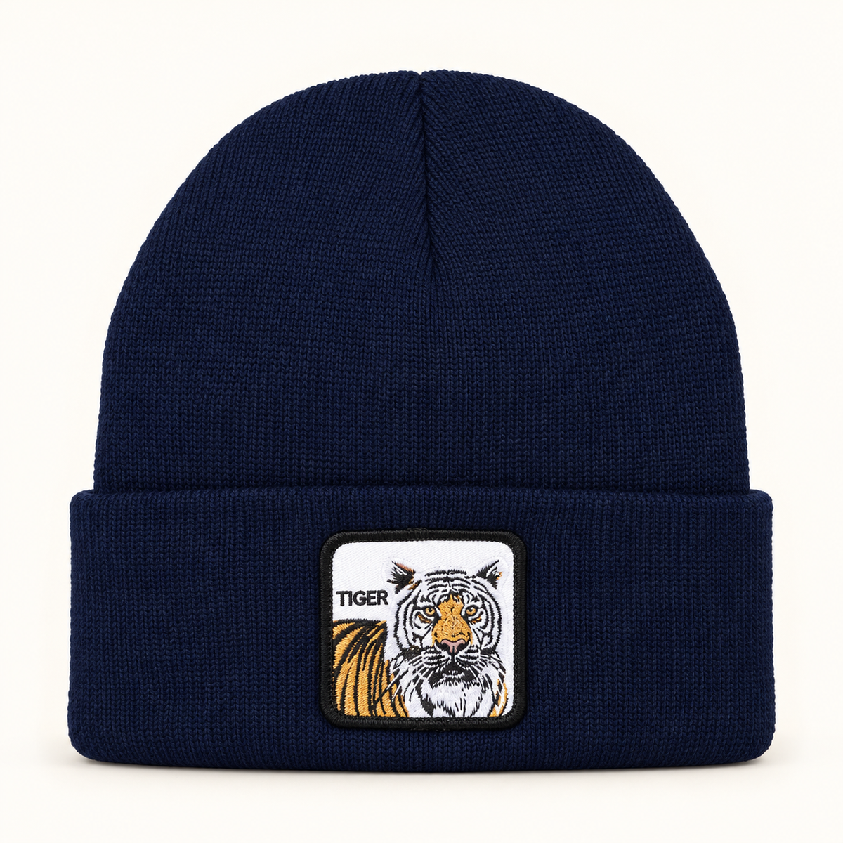 Navy tiger-patch knit beanie, single hat on a clean off-white background.