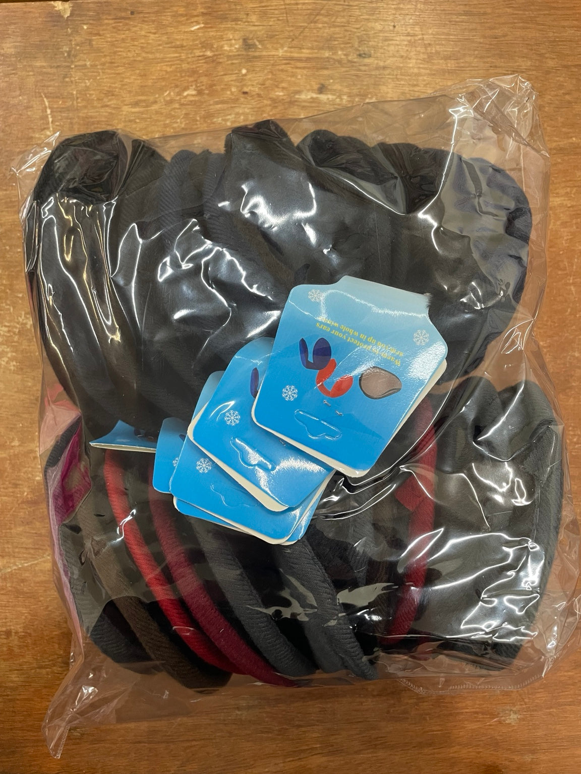 Original photo of the full dozen pack of assorted wraparound earmuffs in clear packaging