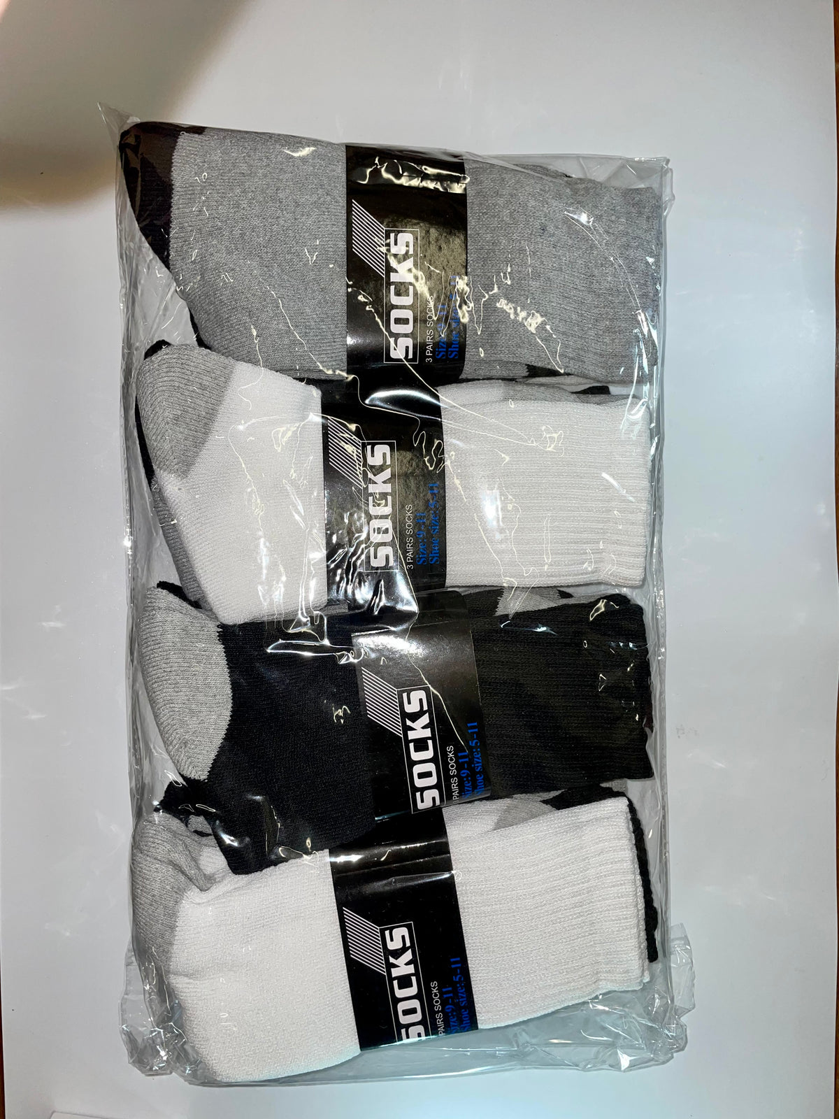 Assorted white, gray and black crew socks in a package