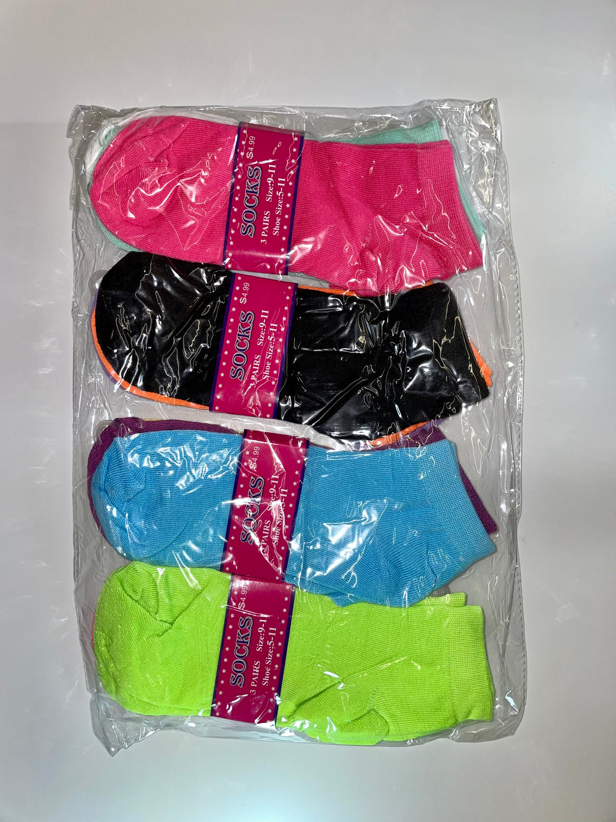 Packaged women’s ankle socks in pink, black, blue and green