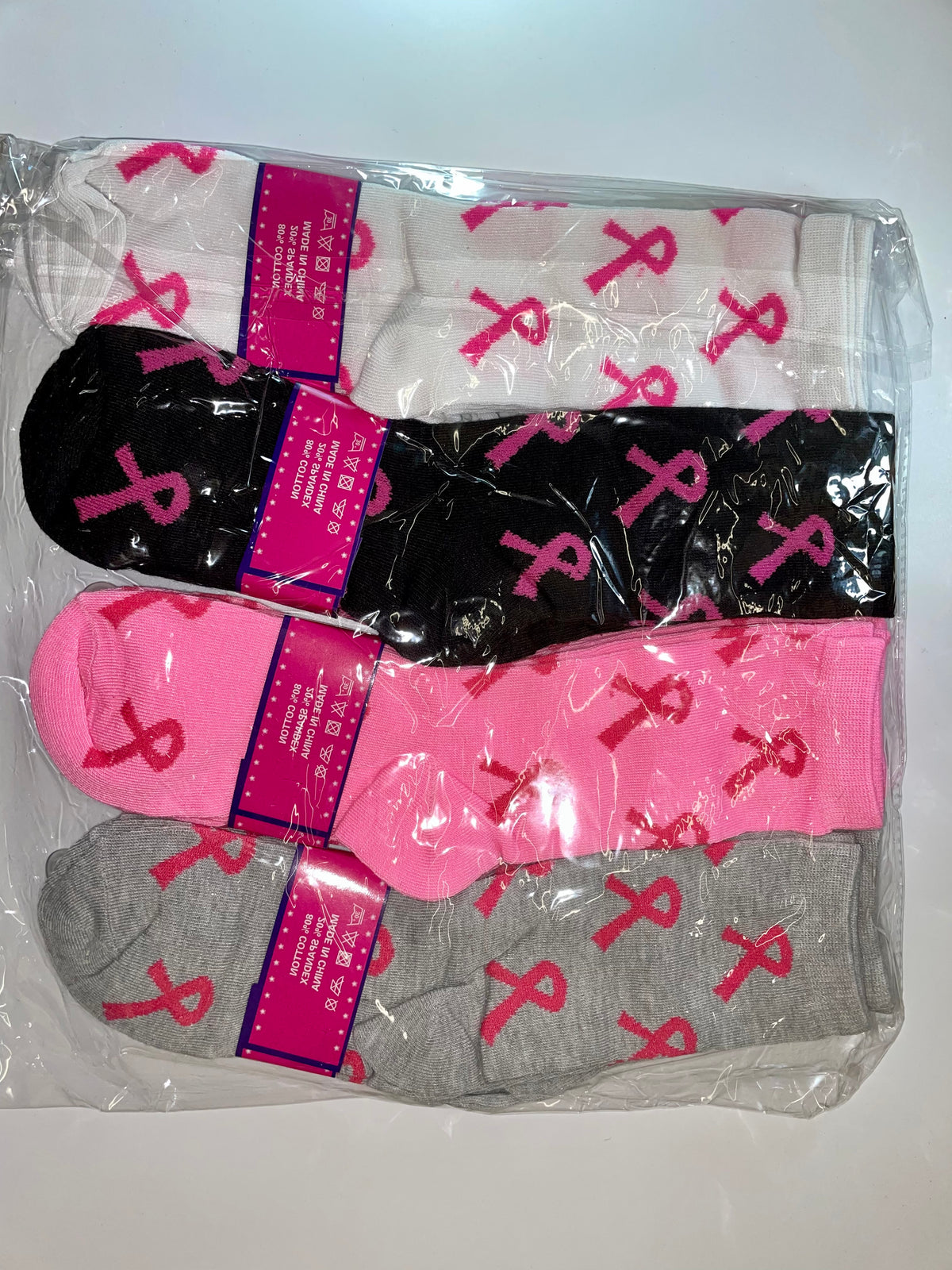 Packaged women’s crew socks with pink ribbon patterns