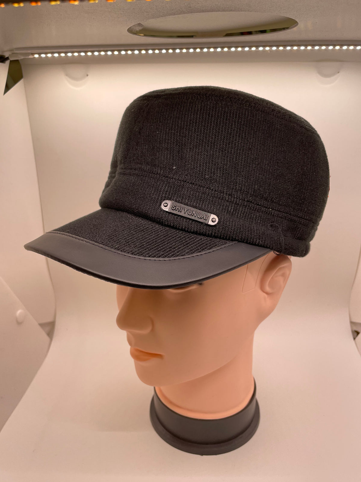 Dark winter cap shown with ear flaps folded up