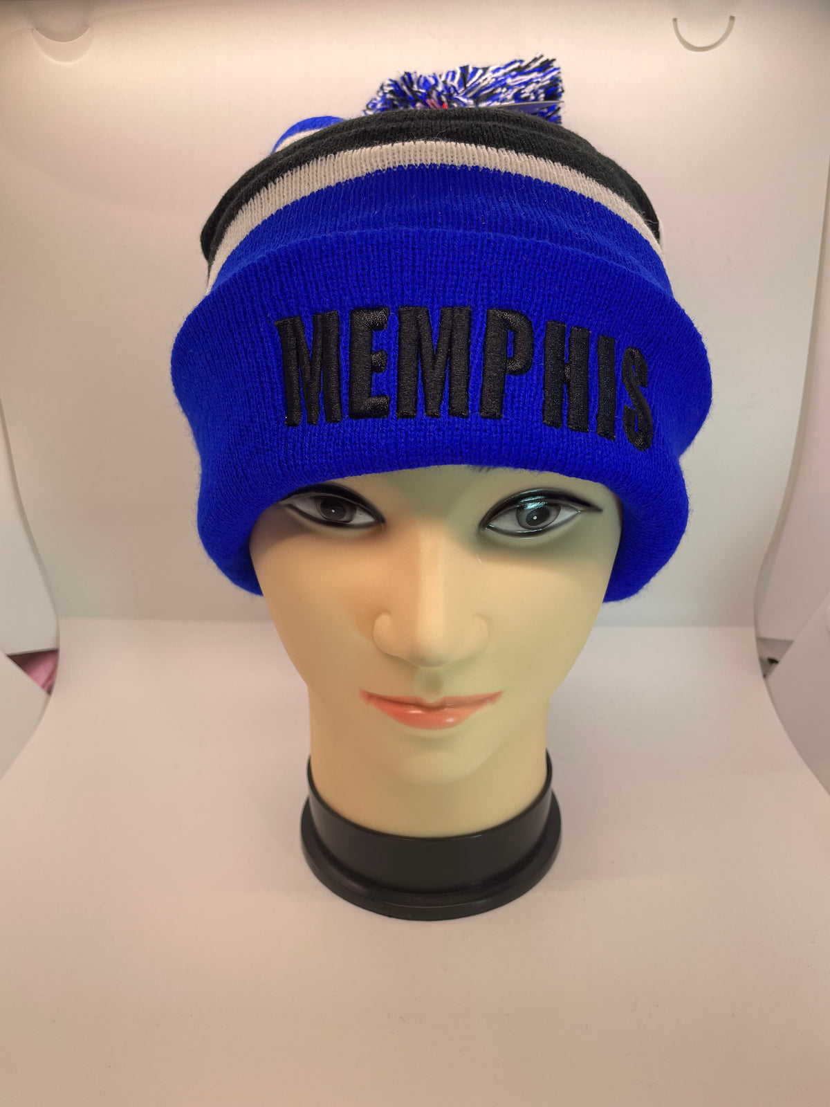 Blue Memphis pom-pom toboggan hat on a mannequin